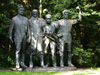 „Keturi komunari“ - soudobá historiografie paroduje tuto sochu jako čtyři opilé kamarády, kteří vlečou toho nejopilejšího k taxíku.