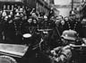 Výmluvné obrázky pražských ulic z 15. března 1939. Zatímco Češi hrozí pěstmi, většina pražských Němců vítá německou armádu zdviženou pravicí. (Zdroj: VÚA)